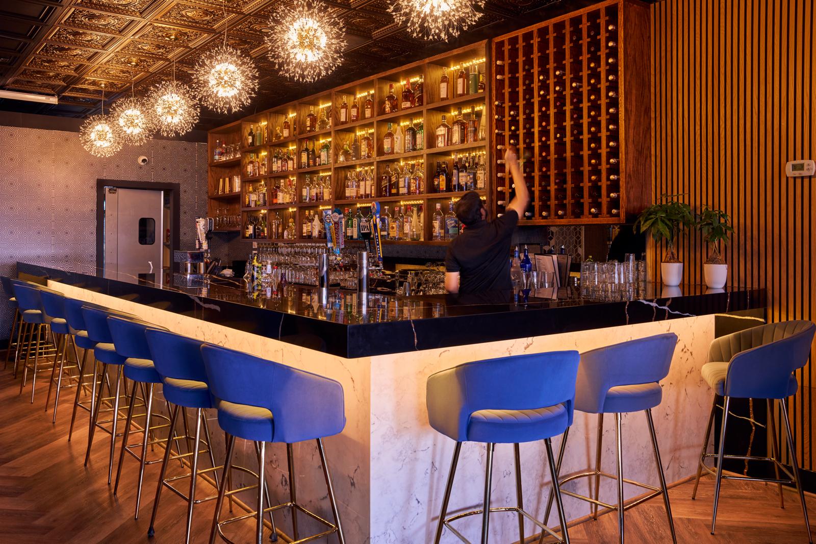 Bar with bartender, firework pendants and backlit spirit wall