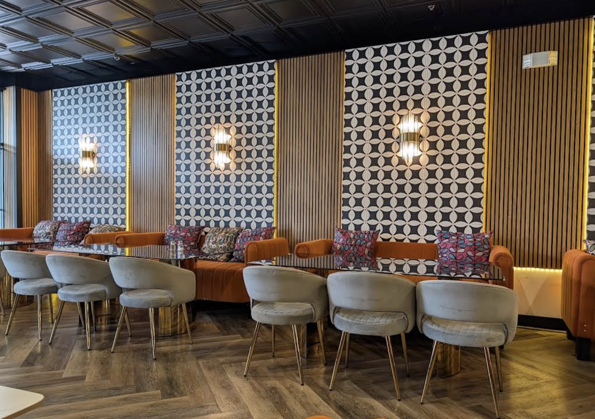 Terracotta banquette with geometric wallpaper panels and gold accents