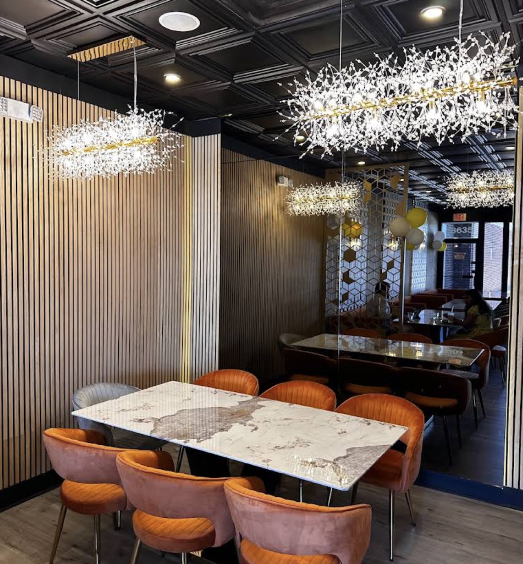 Semi-private dining alcove with crystal branch chandeliers and marble table